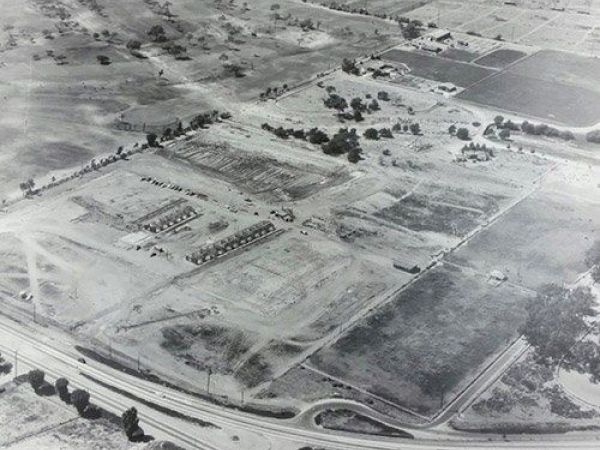 An aerial view of a developing area with partially constructed buildings, roads, and patches of undeveloped land.