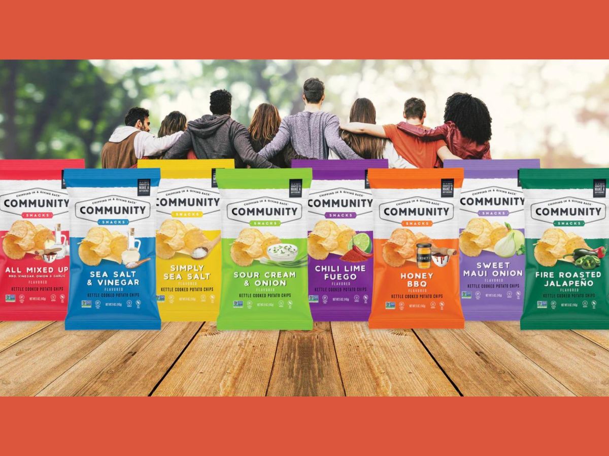 The image shows seven bags of Community-brand potato chips in different flavors with a group of people standing together in the background.